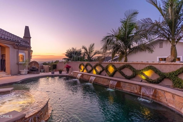 pool at dusk with pool water feature