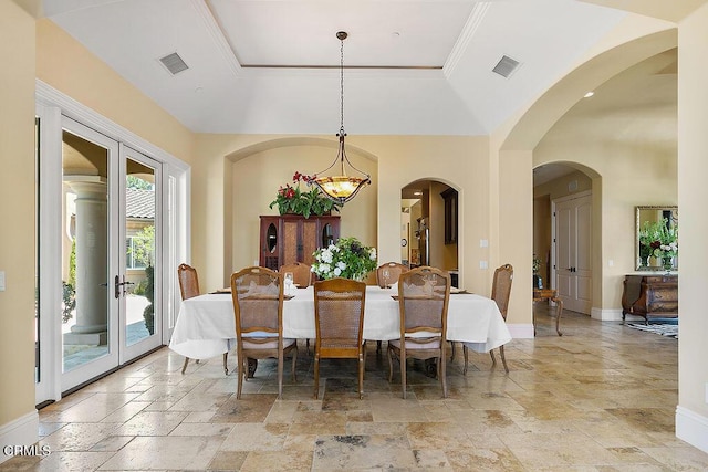 dining area with french doors and a tray ceiling