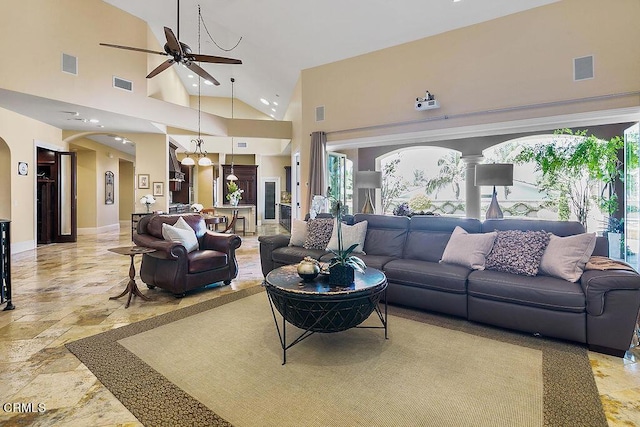 living room with ceiling fan and a high ceiling