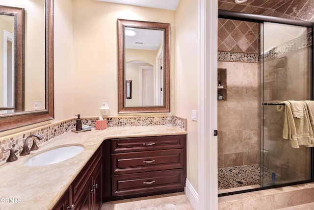 bathroom featuring walk in shower and vanity