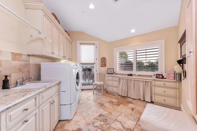 laundry room with washing machine and dryer, sink, and cabinets