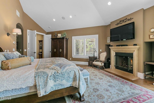 bedroom with hardwood / wood-style flooring and lofted ceiling