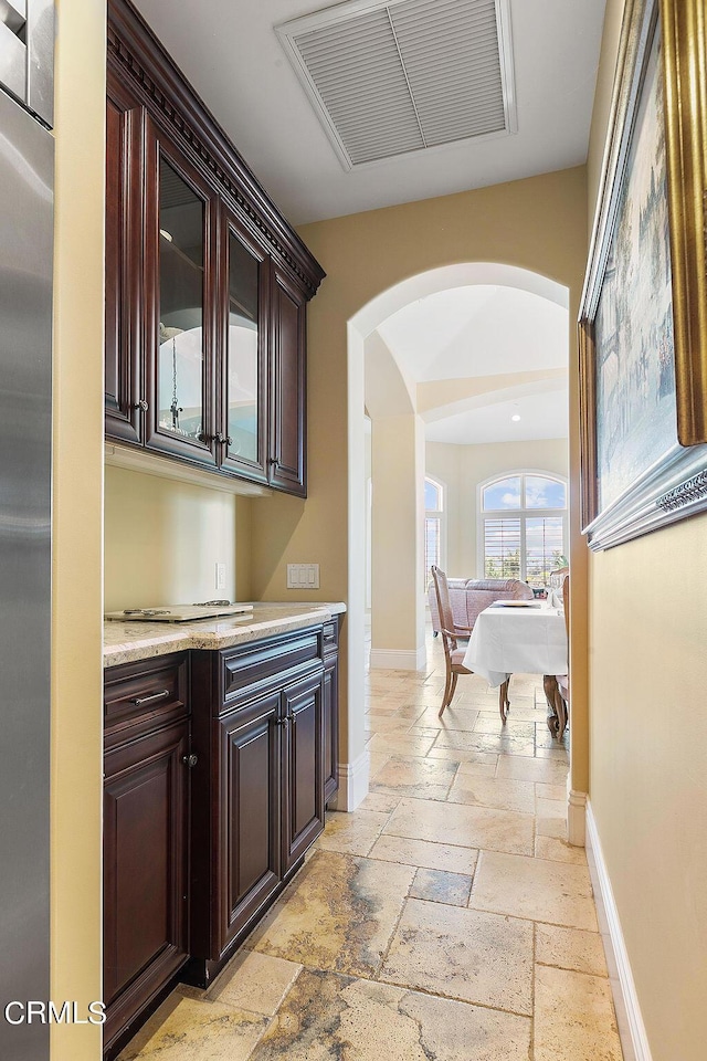 interior space with pool table, dark brown cabinets, and light stone counters