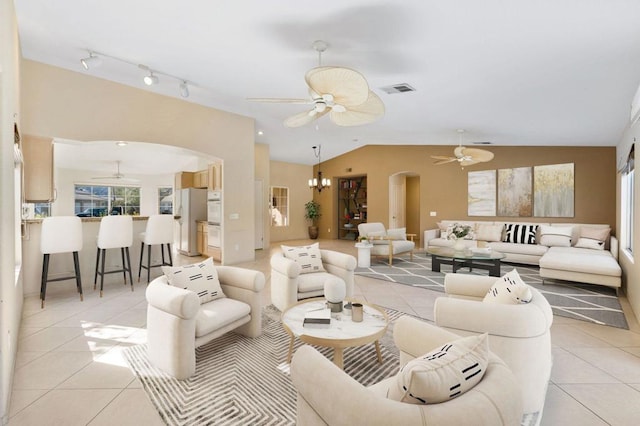 living room with vaulted ceiling, an inviting chandelier, and light tile patterned floors