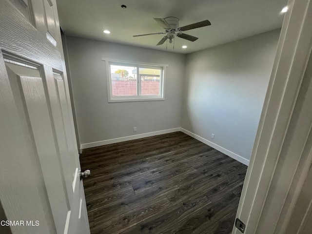 empty room with ceiling fan and dark wood-type flooring