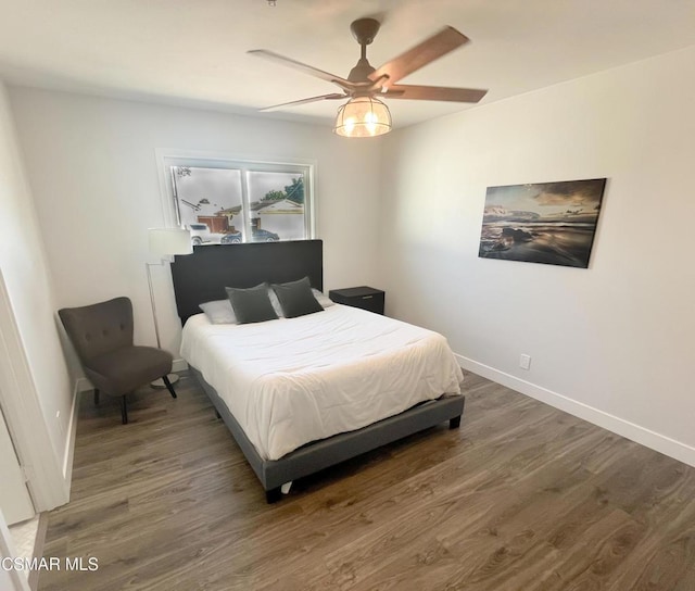 bedroom with ceiling fan and dark hardwood / wood-style flooring