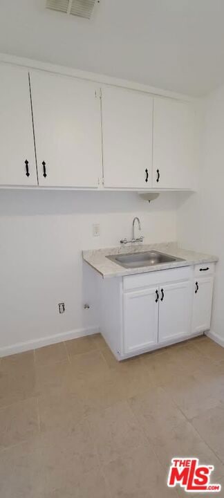 laundry area with sink and light tile patterned flooring