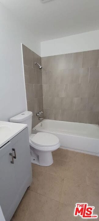 full bathroom with toilet, tiled shower / bath, and vanity