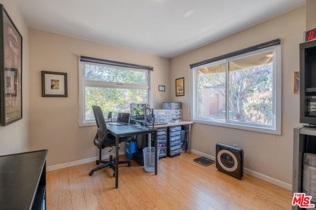 home office featuring a wealth of natural light and light hardwood / wood-style floors