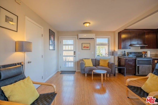 living room featuring light hardwood / wood-style floors and an AC wall unit