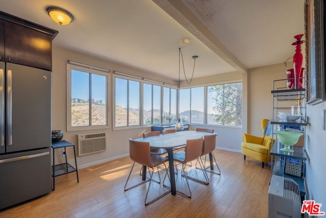 sunroom featuring a wall mounted air conditioner, a wealth of natural light, and beamed ceiling