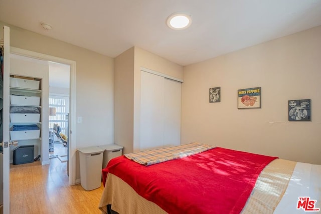 bedroom with light hardwood / wood-style flooring and a closet