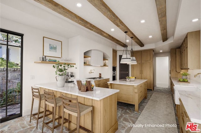 kitchen with decorative light fixtures, a kitchen breakfast bar, a center island, kitchen peninsula, and beam ceiling