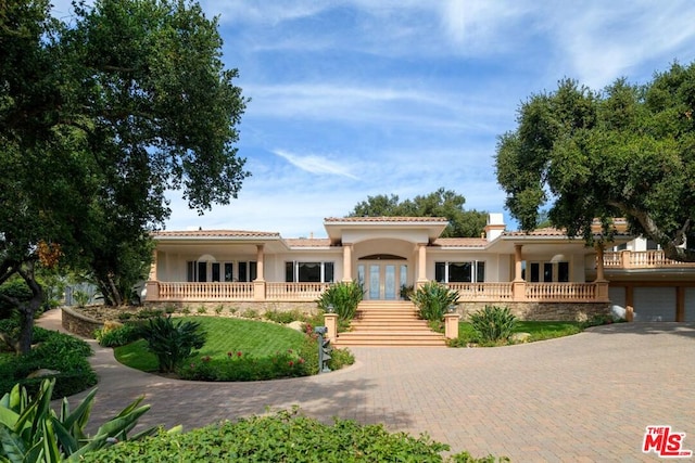 mediterranean / spanish home with a garage and french doors