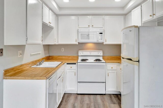 kitchen featuring sink, light hardwood / wood-style flooring, white cabinets, and white appliances