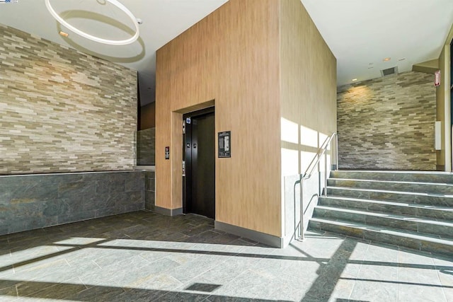 interior space with a towering ceiling and elevator