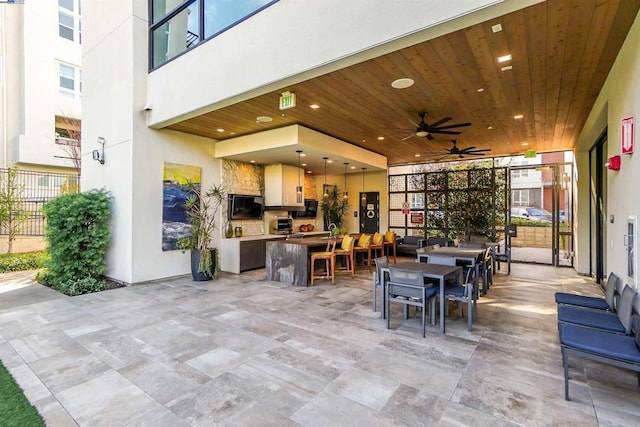 dining room featuring ceiling fan, a wall of windows, and wood ceiling