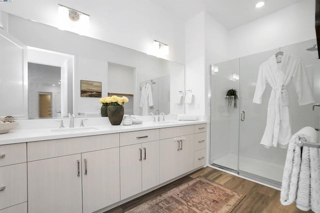 bathroom with hardwood / wood-style flooring, an enclosed shower, and vanity