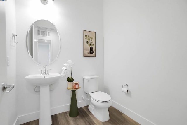 bathroom featuring toilet, wood-type flooring, and sink