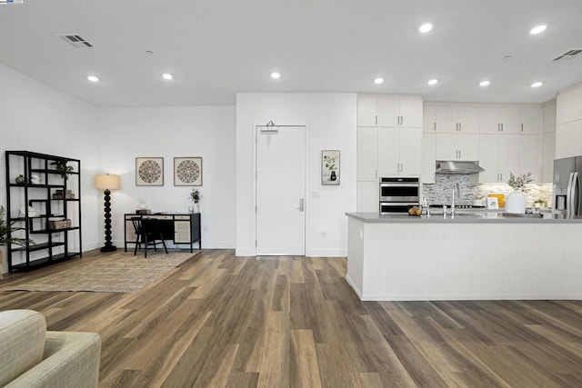 kitchen featuring tasteful backsplash, stainless steel refrigerator with ice dispenser, sink, hardwood / wood-style flooring, and white cabinets