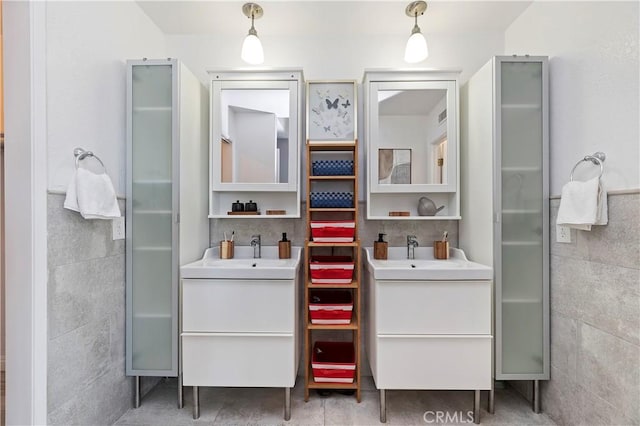 bathroom featuring a shower with shower door, vanity, and tile walls