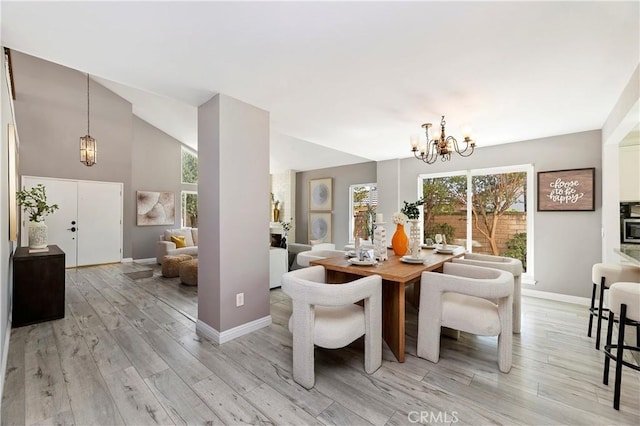 dining space featuring light hardwood / wood-style floors, lofted ceiling, and a chandelier