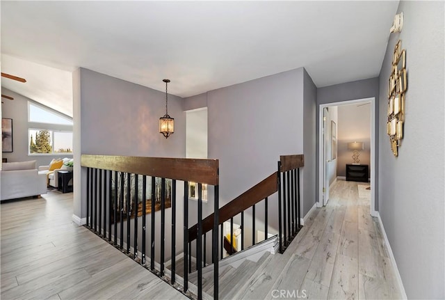 hallway with light hardwood / wood-style flooring and vaulted ceiling