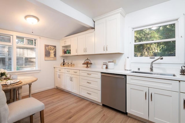 kitchen with stainless steel dishwasher, sink, vaulted ceiling with beams, light hardwood / wood-style floors, and white cabinetry