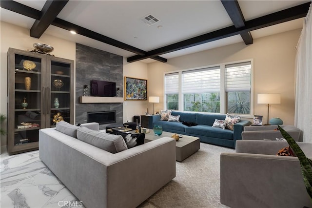 living room with beam ceiling and a tiled fireplace