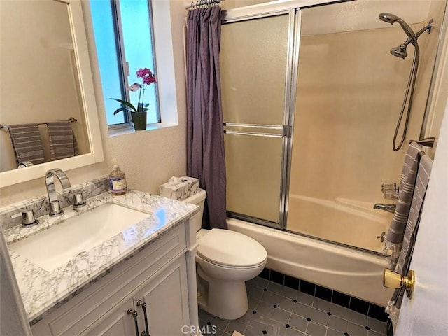 full bathroom featuring tile patterned floors, shower / bath combination with glass door, vanity, and toilet