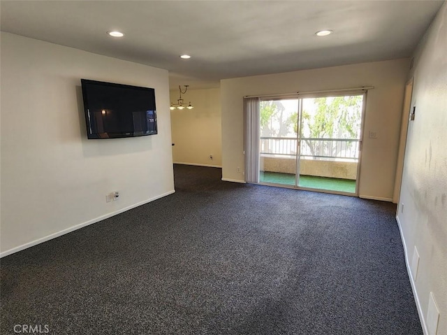 spare room with dark colored carpet