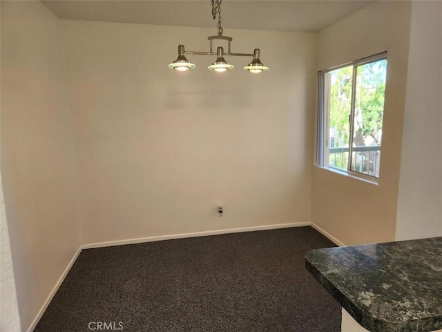 unfurnished dining area featuring dark carpet