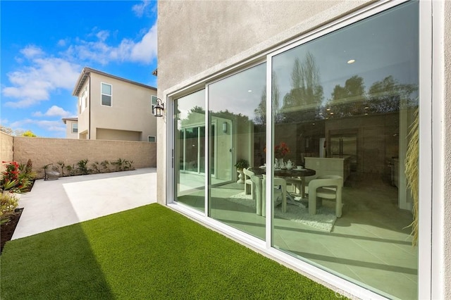 exterior space with a yard, stucco siding, a patio, and fence