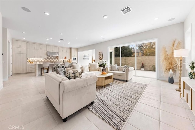 living area with light tile patterned floors, baseboards, visible vents, and recessed lighting