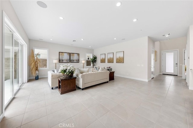 living area featuring baseboards, light tile patterned floors, and recessed lighting