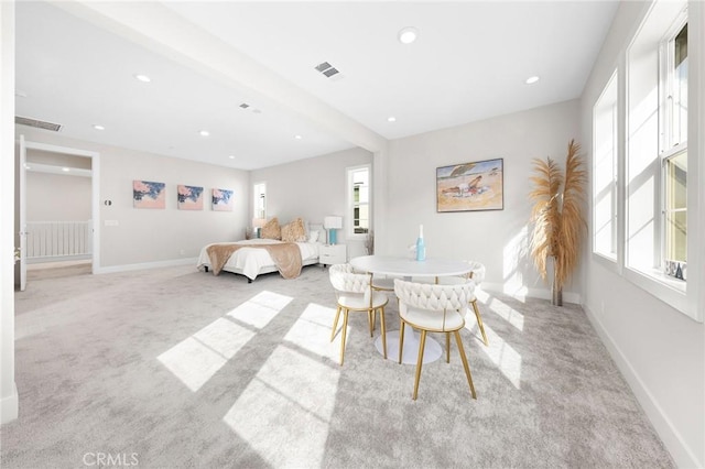 dining room with a healthy amount of sunlight, visible vents, and light colored carpet