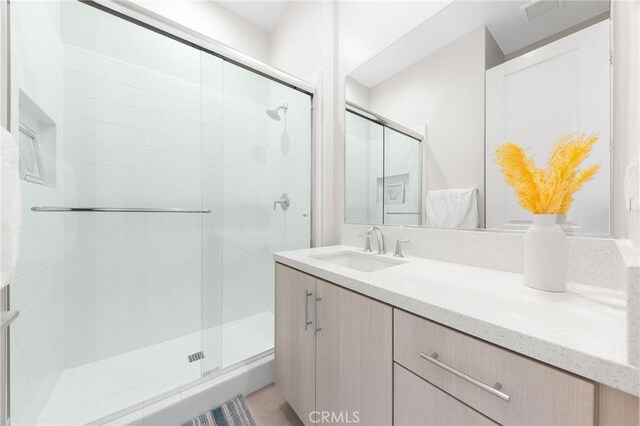 bathroom featuring an enclosed shower and vanity