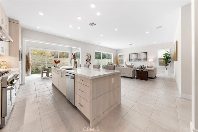 kitchen with recessed lighting, appliances with stainless steel finishes, a sink, modern cabinets, and a large island with sink