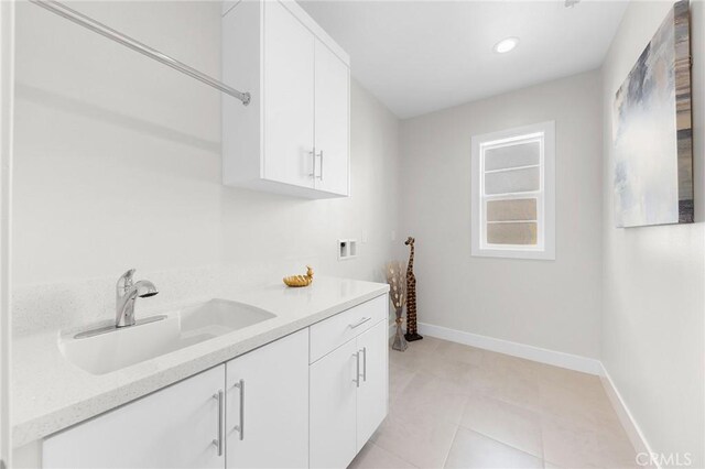 laundry room featuring cabinets, sink, hookup for a washing machine, and a healthy amount of sunlight