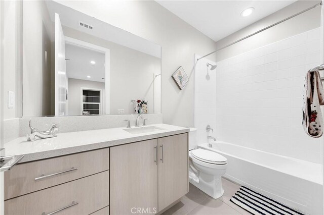 full bathroom featuring toilet, vanity, tile patterned floors, and shower / tub combination