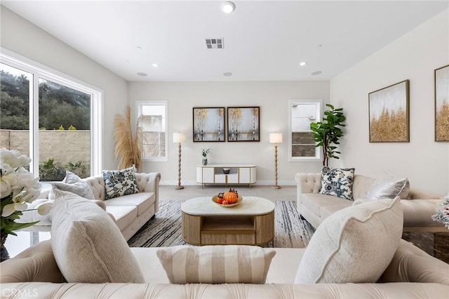 living room with baseboards, visible vents, and recessed lighting