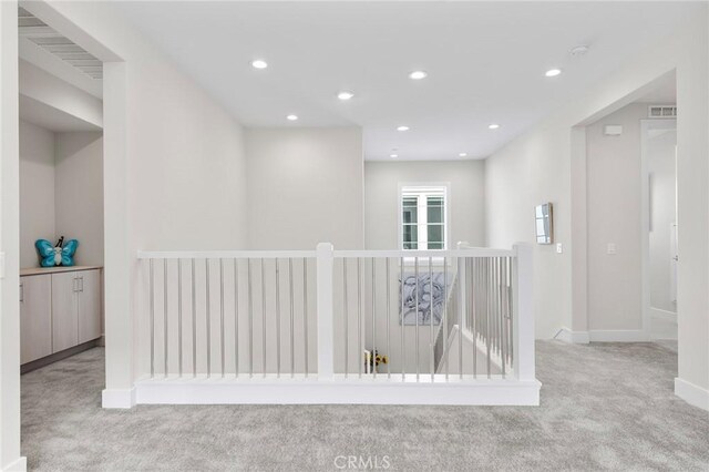 hallway with baseboards, visible vents, carpet flooring, an upstairs landing, and recessed lighting