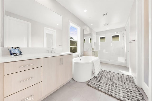 bathroom featuring visible vents, vanity, a shower stall, a freestanding tub, and tile patterned floors