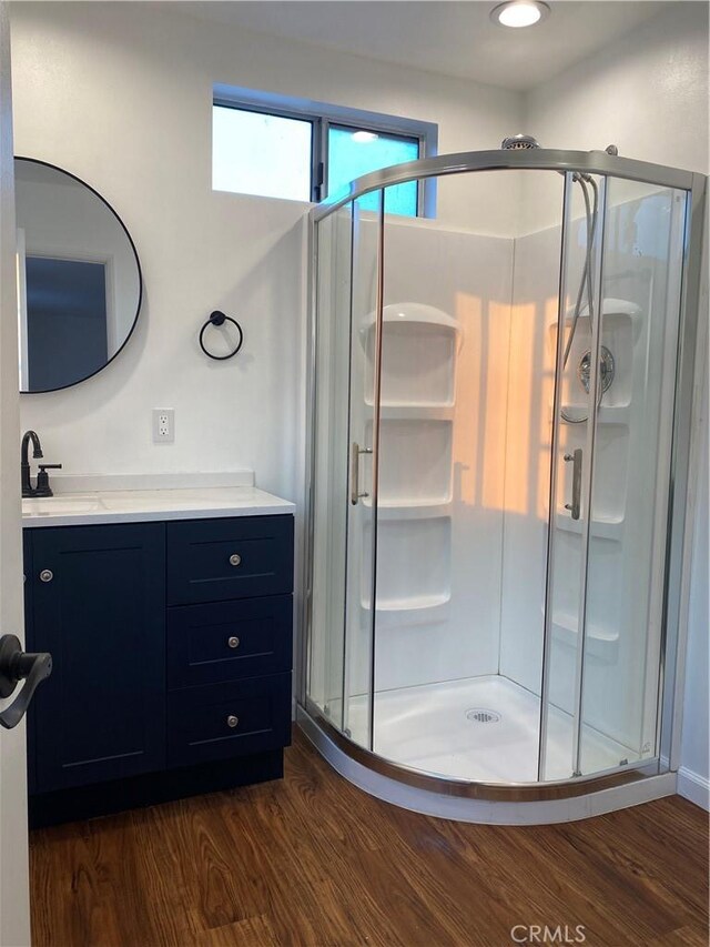 bathroom featuring vanity, wood-type flooring, and walk in shower