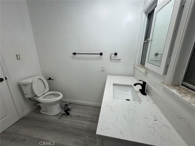 bathroom with hardwood / wood-style flooring, vanity, and toilet