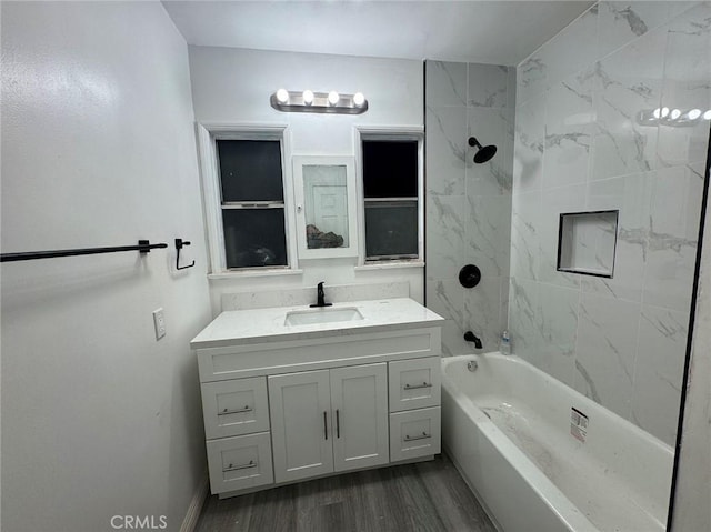 bathroom featuring tiled shower / bath, hardwood / wood-style floors, and vanity