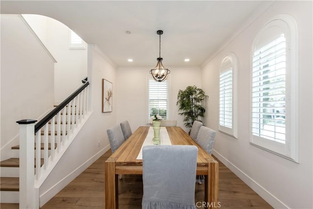 dining area featuring crown molding, hardwood / wood-style floors, and a notable chandelier