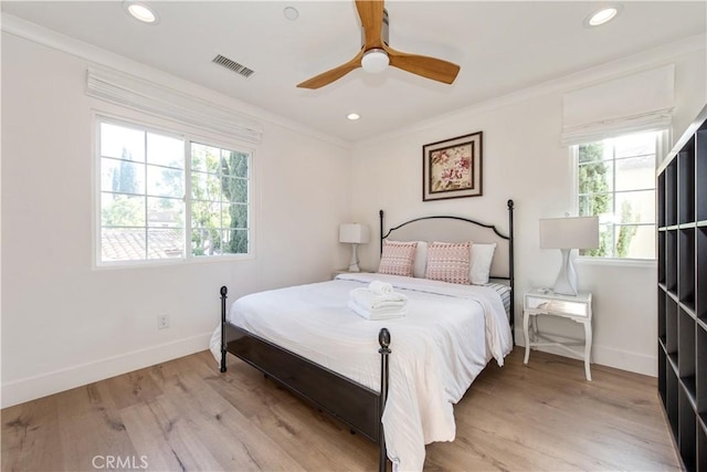 bedroom with ceiling fan, ornamental molding, and light wood-type flooring