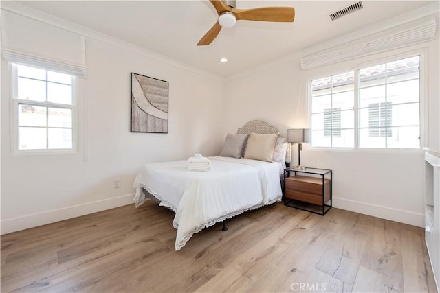 bedroom with ceiling fan, crown molding, and light hardwood / wood-style floors