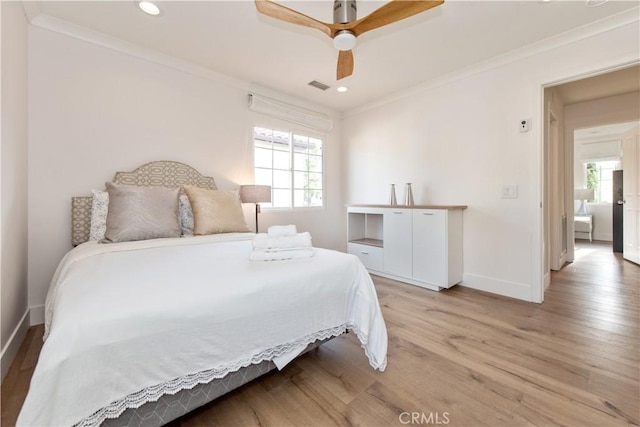 bedroom featuring ceiling fan, light hardwood / wood-style floors, and crown molding